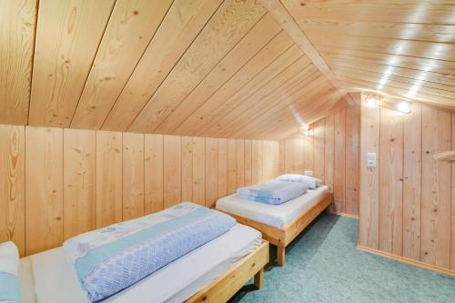 two beds in a sauna with wooden walls at Ferienwohnung Morgenrot in Wackersberg
