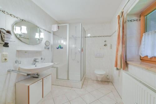 a white bathroom with a shower and a sink at Ferienwohnung Morgenrot in Wackersberg
