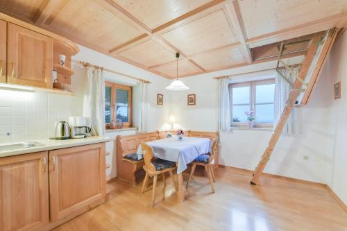a kitchen with a table and chairs in a room at Ferienwohnung Morgenrot in Wackersberg