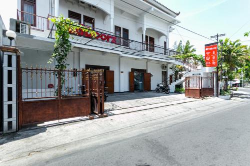 un edificio bianco con un cancello su una strada di RedDoorz near Puro Mangkunegaran a Solo
