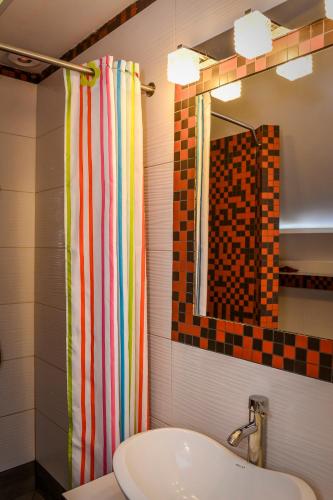 a bathroom with a sink and a shower curtain at Gama Spa in Władysławowo