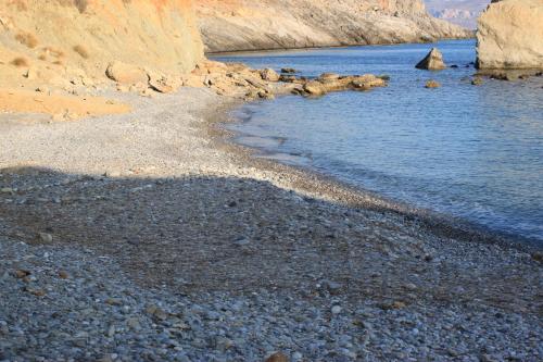 a rocky beach with a body of water at Kalo Nero Apartments in Makry Gialos