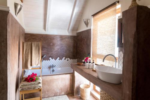 a bathroom with a large sink and a tub at Clove Island Villas & Spa in Makunduchi