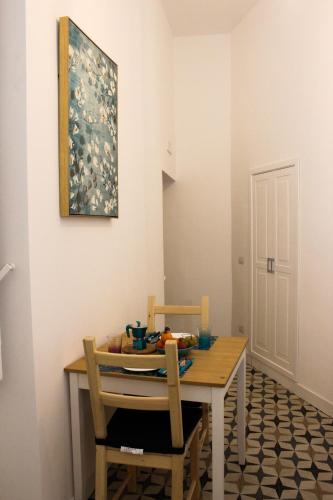a dining room table with two chairs and a painting at Le Chiavi di Casa in Naples