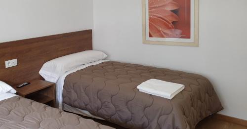 a small bedroom with a bed and a picture on the wall at Pension Cando in Porriño