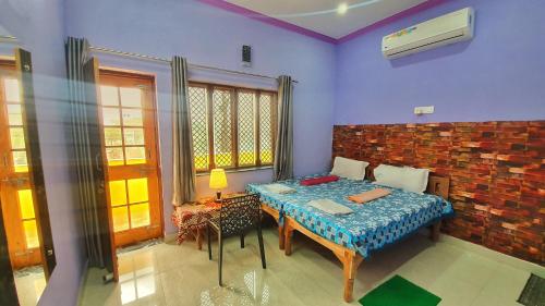 a room with a bed and a table in it at Anukampa Paying Guest House in Agra