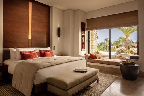 a bedroom with a large bed and a large window at Anantara Sahara-Tozeur Resort & Villas in Tozeur