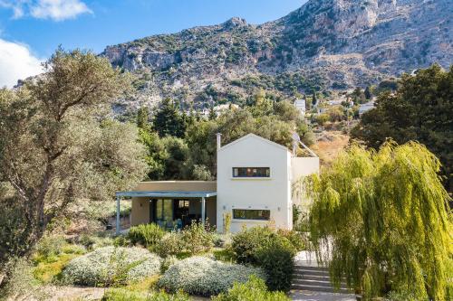 a white house with a mountain in the background at Tessera Villa, a Serene Escape in Nature with Pool, By ThinkVilla in Spílion