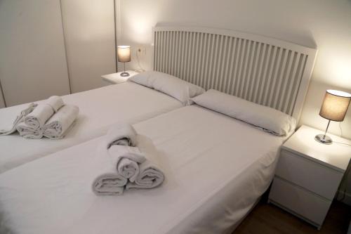 1 dormitorio con 2 toallas en una cama blanca en Plaza Monterrey parking opcional by Salamancavacacional, en Salamanca