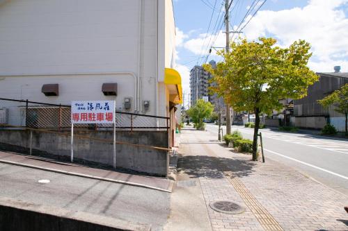 a building with a sign on the side of a street at Grand Hotel Seifuso in Ōmuta
