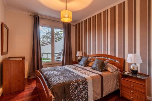 フンシャルにあるCasa Branca with garden by HR Madeiraのベッドルーム1室(ベッド1台、大きな窓付)