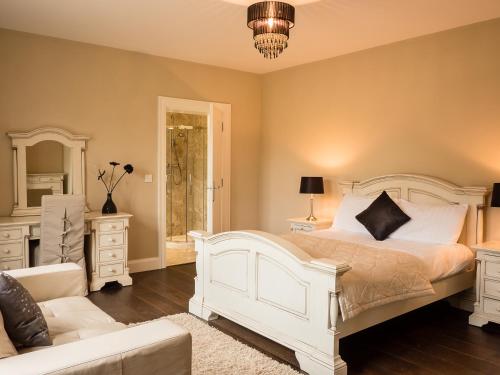 a bedroom with a white bed and a couch at The Willows at Mullans Bay in Kesh