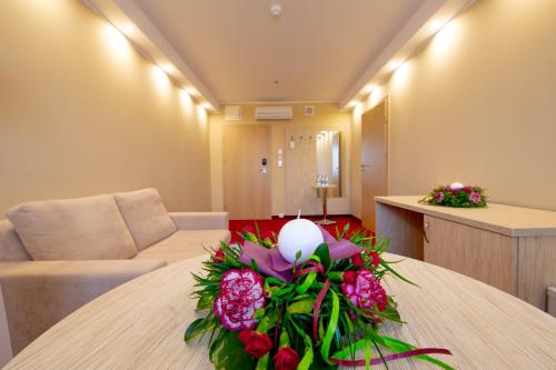 a room with a table with a bouquet of flowers on it at Hotel 500 in Tarnowo Podgórne