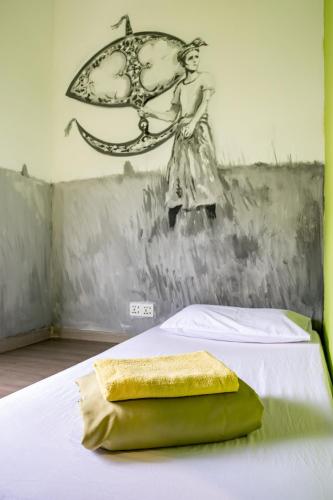 a bedroom with a painting of a woman on a bed at PODs The Backpackers Home & Cafe, Kuala Lumpur in Kuala Lumpur