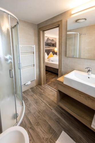 a bathroom with a sink and a shower and a mirror at Hotel Alpenblick in Pfelders