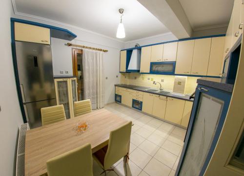 a kitchen with a wooden table and chairs at Vier Luxury House in Serres