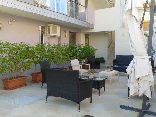 a patio with chairs and tables and potted plants at Suliccenti Marzamemi in Marzamemi