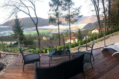 a deck with chairs and a table with a view at Nature View House with Sauna in Tolmin