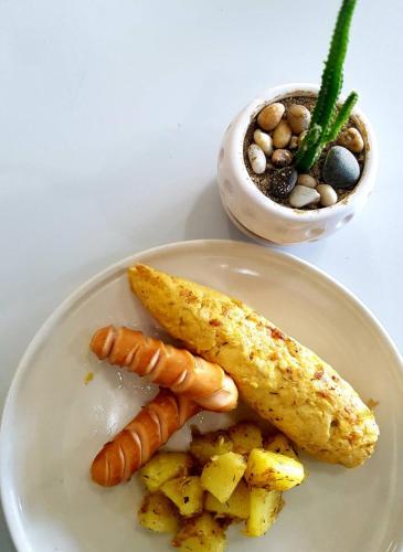 a plate of food with carrots and potatoes on a table at BanPunmanus Hotel in Krabi town