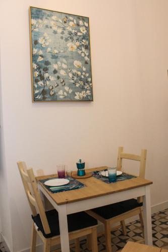 a table with two chairs and a painting on the wall at Le Chiavi di Casa in Naples