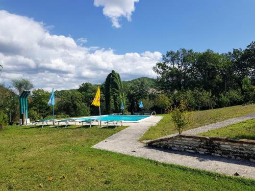 una piscina en un campo de césped con banderas en Cà Maggio Nuovo, en Acqualagna