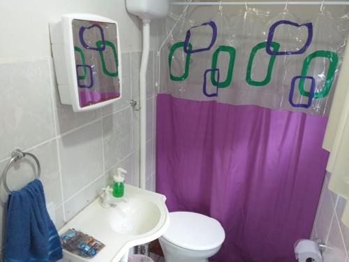 baño con cortina de ducha púrpura y aseo en Residencial Ponta Norte, en Florianópolis