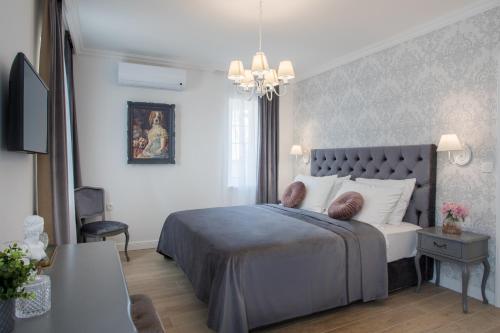 ein Schlafzimmer mit einem großen Bett und einem Kronleuchter in der Unterkunft Vila Alta in Selce