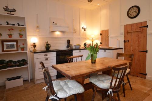 een keuken met een houten tafel en stoelen bij Darroch Beag in Saint Catherines