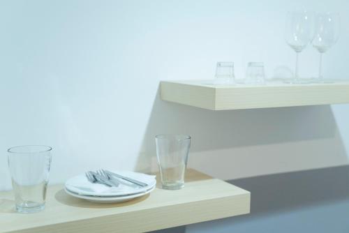a table with two glasses and a plate and napkin at Maria Boutique Suits in Budapest
