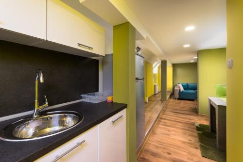 a kitchen with a sink and a living room at Serdika Round Tower Apartments in Sofia