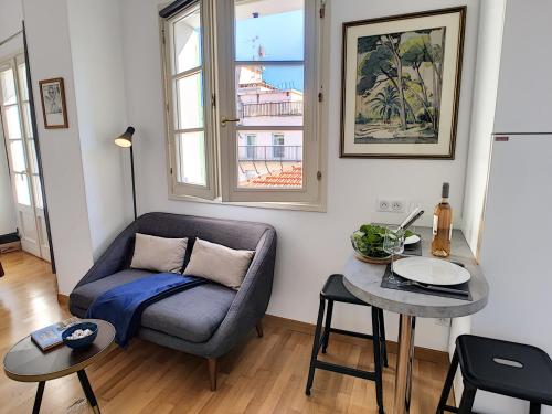 un salon avec un canapé bleu et une table dans l'établissement Nestor&Jeeves - GRIMALDI PLAZA - Quartier réputé - Proche plage, à Nice