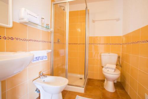 a bathroom with a shower and a toilet and a sink at Complesso Residenziale Marina di Pinarello in Pinarellu