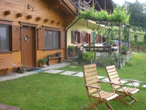 two chairs sitting in a yard next to a house at Pera Rionda in Caprie
