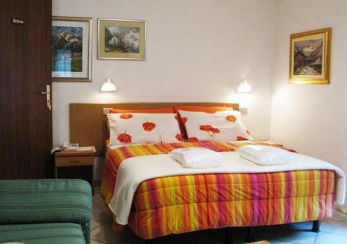 a bedroom with a large bed with a colorful blanket at Hotel Bucaneve in Pré-Saint-Didier
