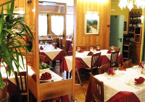 a restaurant with tables and chairs with red napkins at Hotel Bucaneve in Pré-Saint-Didier