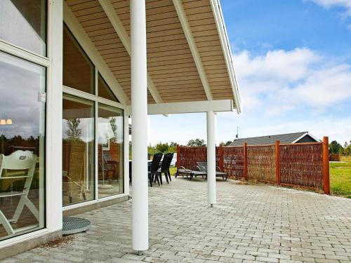 a patio with tables and chairs and a fence at 12 person holiday home in R dby in Kramnitse