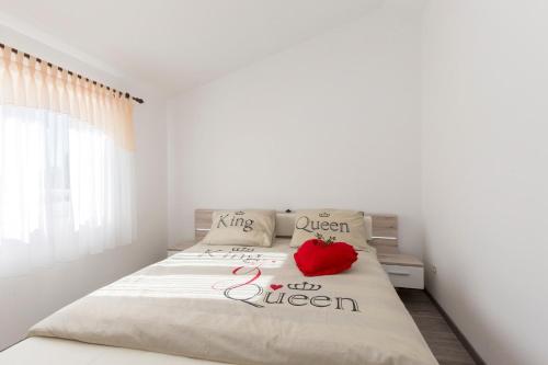 een slaapkamer met een bed met een rode appel erop bij Villa Piljan in Bokordići
