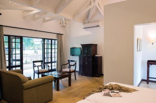 a room with a bed and a living room at Perry's Bridge Hollow Boutique Hotel in Hazyview