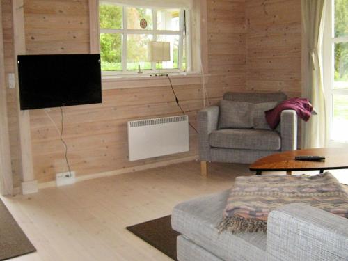 sala de estar con TV, sofá y silla en 6 person holiday home in Skibby, en Skibby