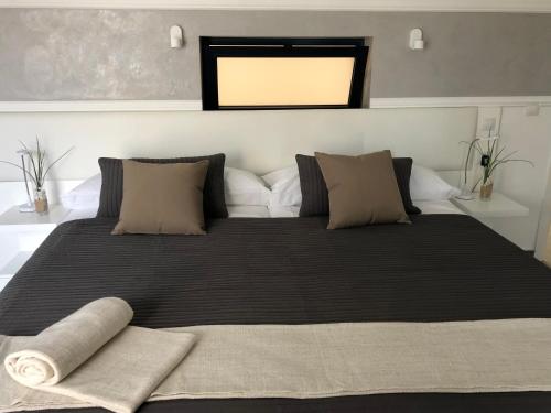 a bedroom with a large bed with black sheets and pillows at Fuertevillage in Costa Calma