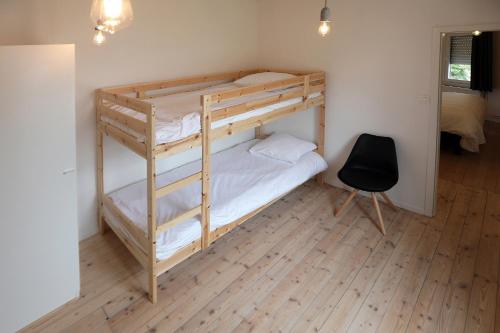 Zimmer mit 2 Etagenbetten und einem Stuhl in der Unterkunft Loft vakantiehuis in Veurne