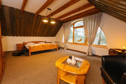a bedroom with a bed and a table in a room at Atpūtas komplekss Lācītes in Ranka