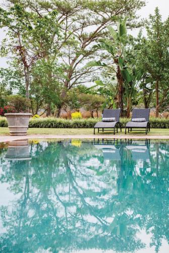 two chairs sitting next to a pool of water at Perry's Bridge Hollow Boutique Hotel in Hazyview