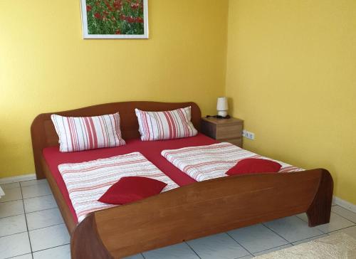 um quarto com uma cama com almofadas vermelhas e brancas em Ferienwohnung Punkt-Schönstein em Kappel-Grafenhausen