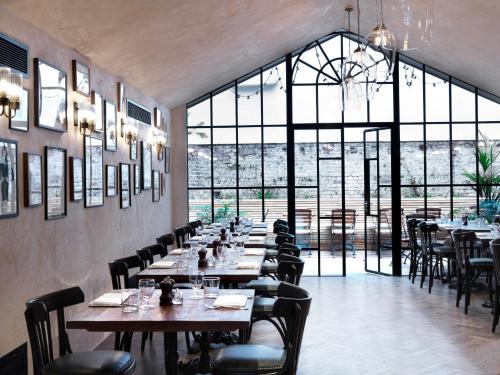 um restaurante com mesas e cadeiras e uma grande janela em The Coach em Londres