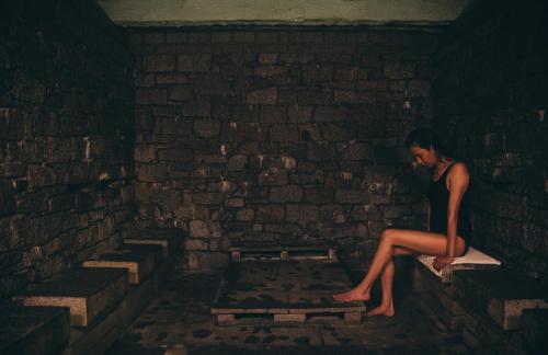 a woman sitting on a brick wall next to a brick wall at Hotel Manantial in Caldes de Boi