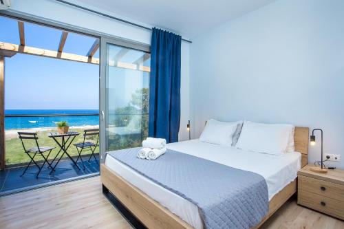 a bedroom with a bed and a view of the ocean at Rhodes Sea Villas in Ixia