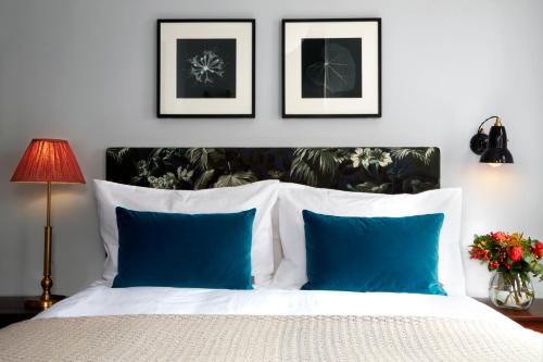 1 dormitorio con cama blanca y almohadas azules en The Coach, en Londres