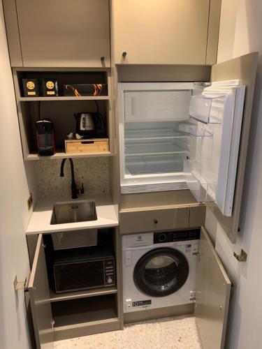 una piccola cucina con frigorifero e lavandino di PARIS RIVOLI NOTRE DAME Chambre d'Hôtes Studio Private a Parigi