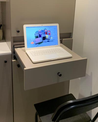 un ordinateur portable installé au-dessus d'un bureau dans l'établissement PARIS RIVOLI NOTRE DAME Chambre d'Hôtes Studio Private, à Paris